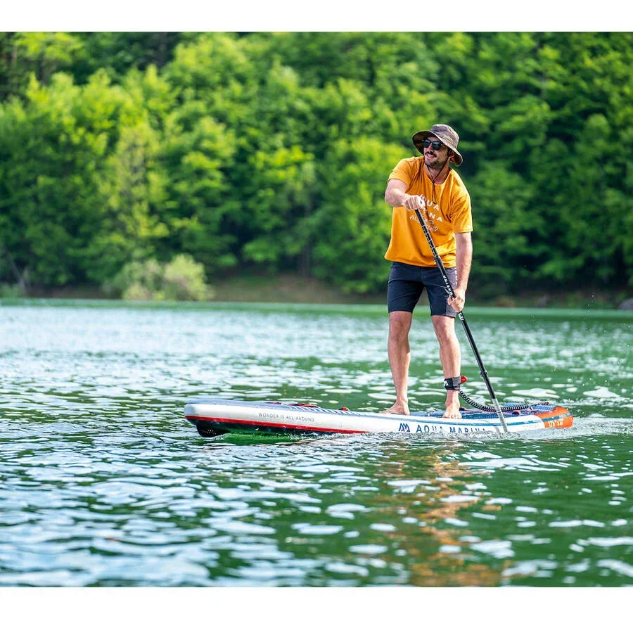 Doğada, gölde kürekle SUP board üzerinde duran erkek, açık hava su sporları