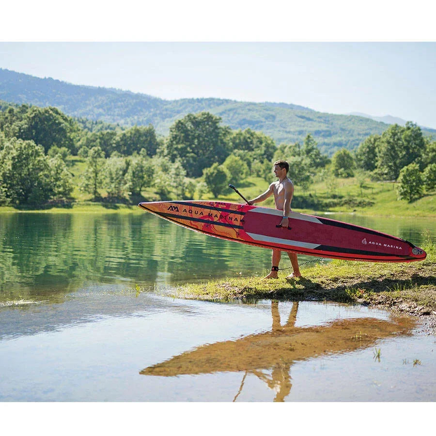 Doğada gölde kırmızı Aqua Marina SUP board taşıyan erkek, su sporları ve açık hava aktiviteleri