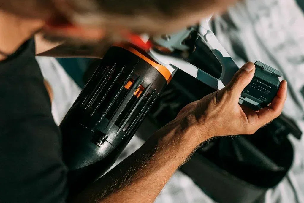 Kişi, portatif su motoru ve Aqua Marina kontrol cihazı tutuyor, açık hava, su sporu ekipmanı