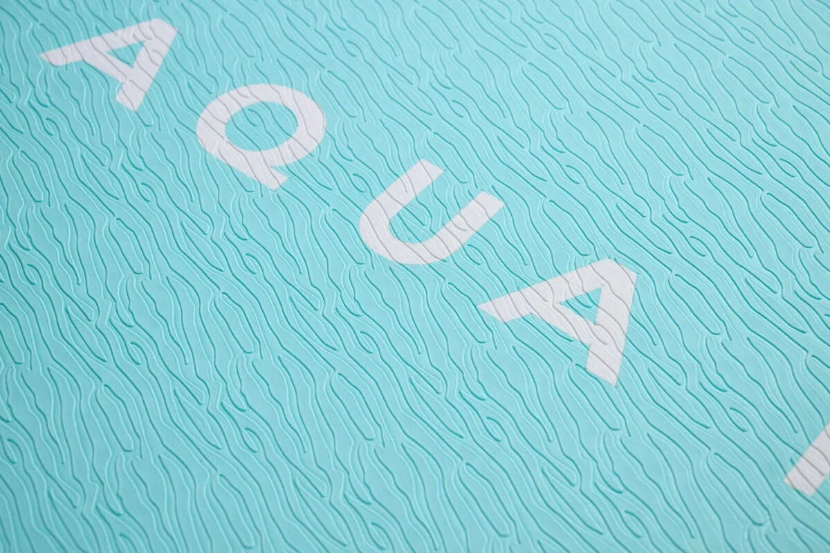 Aqua renklı, dokulu yüzeye sahip SUP board detayı, su sporları ekipmanı.