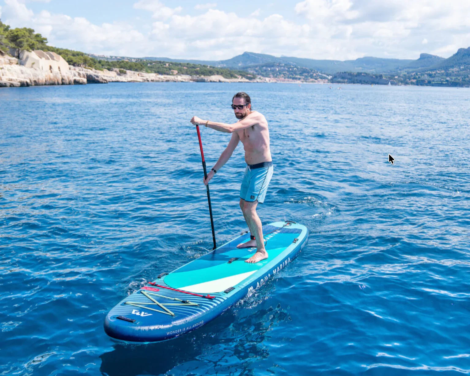 Denizde Aqua Marina SUP board üzerinde kürek çeken adam, açık hava su sporu