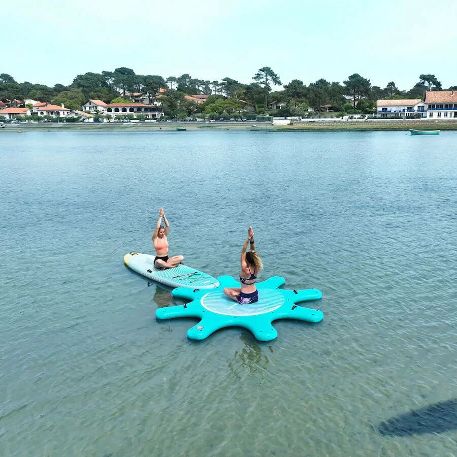 Göldeki şişme yoga platformunda ve SUP board üzerinde yoga yapan iki kişi